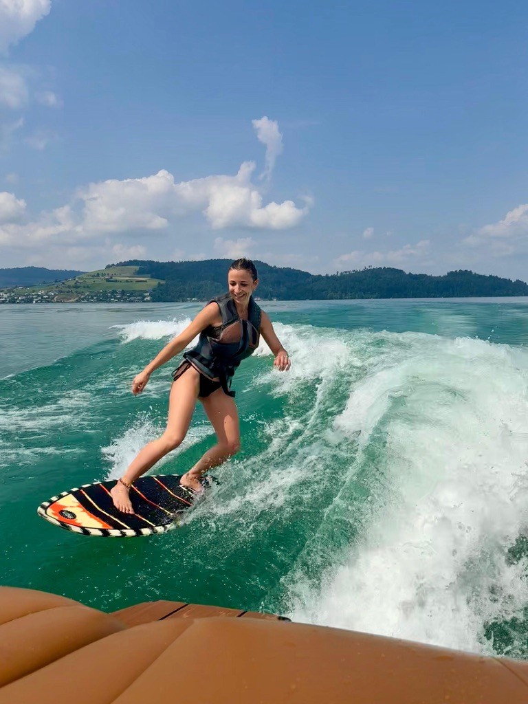 Girl wakesurfing on turquoise blue water on Lake Zug, Switzerland