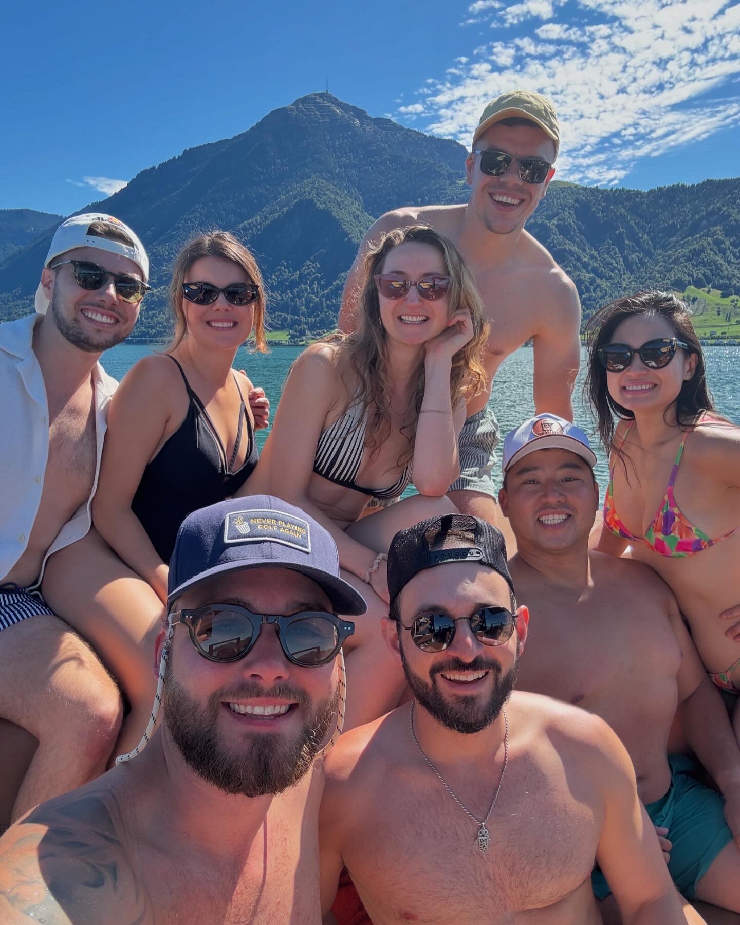 Group of friends smiling on a boat with Mt. Rigi behind on Lake Zug