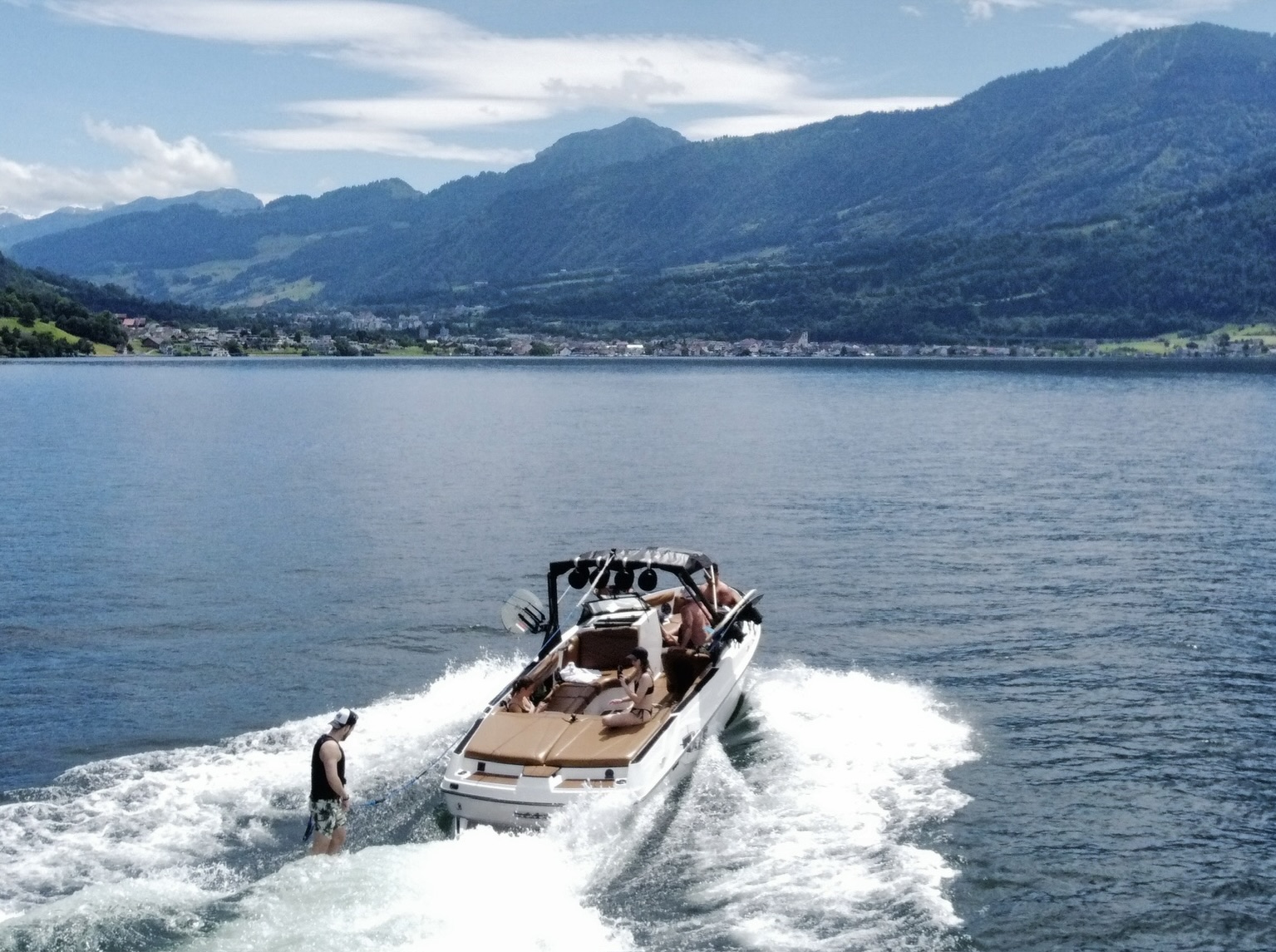 Drone shot of Axis wakeboat with wakesurfer behind on Lake Zug